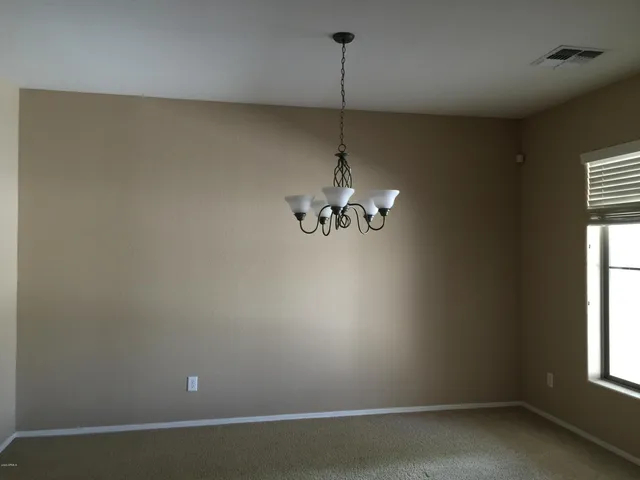 en empty room with window and chandelier fan