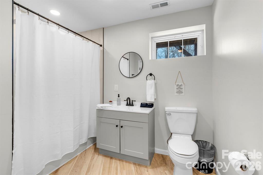 56 Great Horned Owl Road Candler, NC 28715 - Photo 24 of 32 a bathroom with a toilet sink vanity and mirror