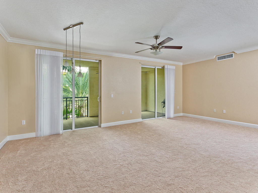 4 Renaissance Way, Unit 303 Boynton Beach, FL 33426 - Photo 11 of 26 a view of an empty room with a ceiling fan and windows