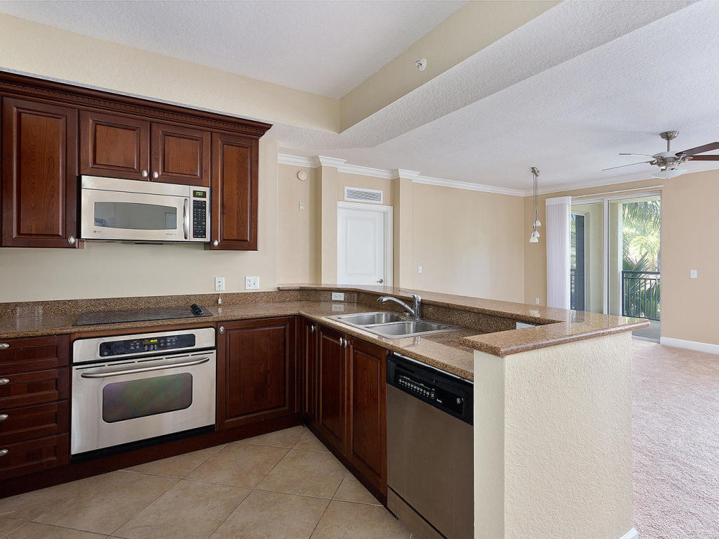 4 Renaissance Way, Unit 303 Boynton Beach, FL 33426 - Photo 10 of 26 a kitchen with stainless steel appliances granite countertop a stove microwave and sink