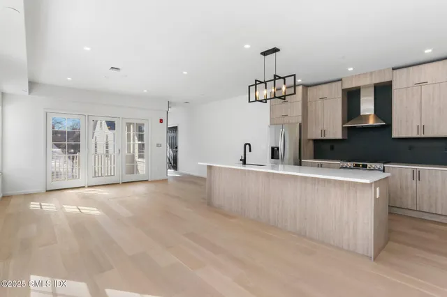 a large kitchen with stainless steel appliances granite countertop a lot of counter space and wooden floors