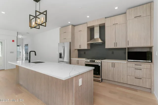 a kitchen with white cabinets and stainless steel appliances