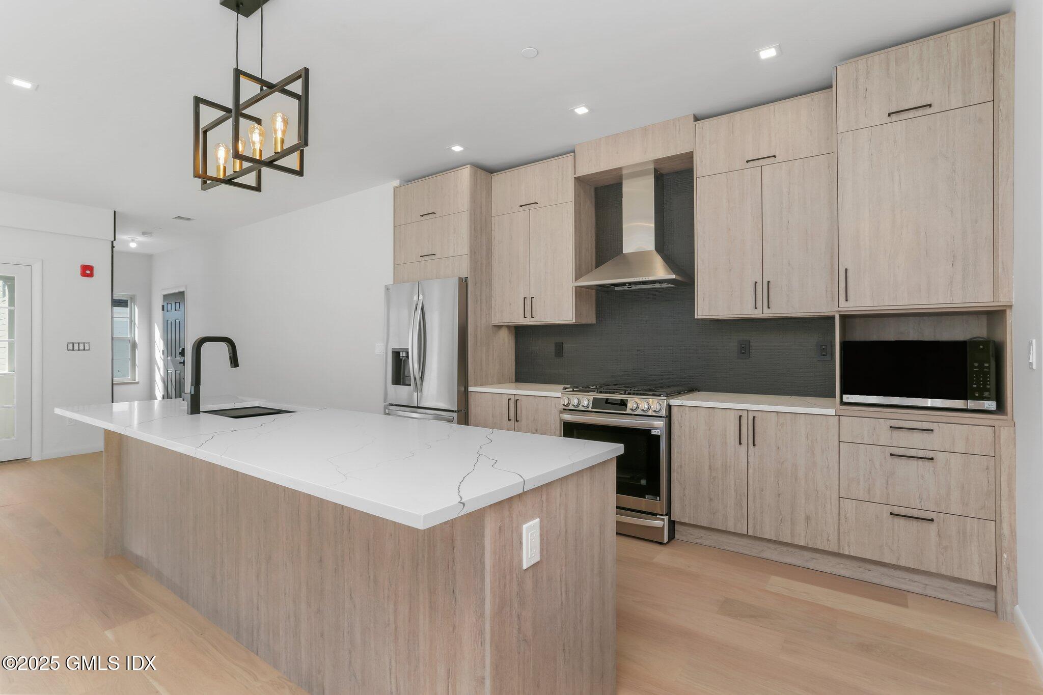63 Church Street, Unit 2R Greenwich, CT 06830 - Photo 4 of 13 a kitchen with white cabinets and stainless steel appliances