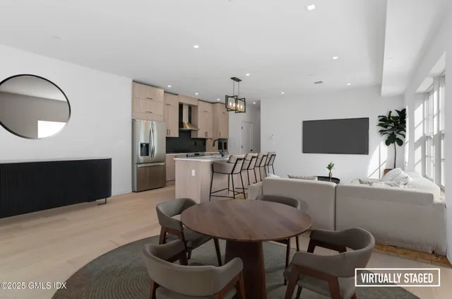 a living room with furniture a flat screen tv and kitchen view