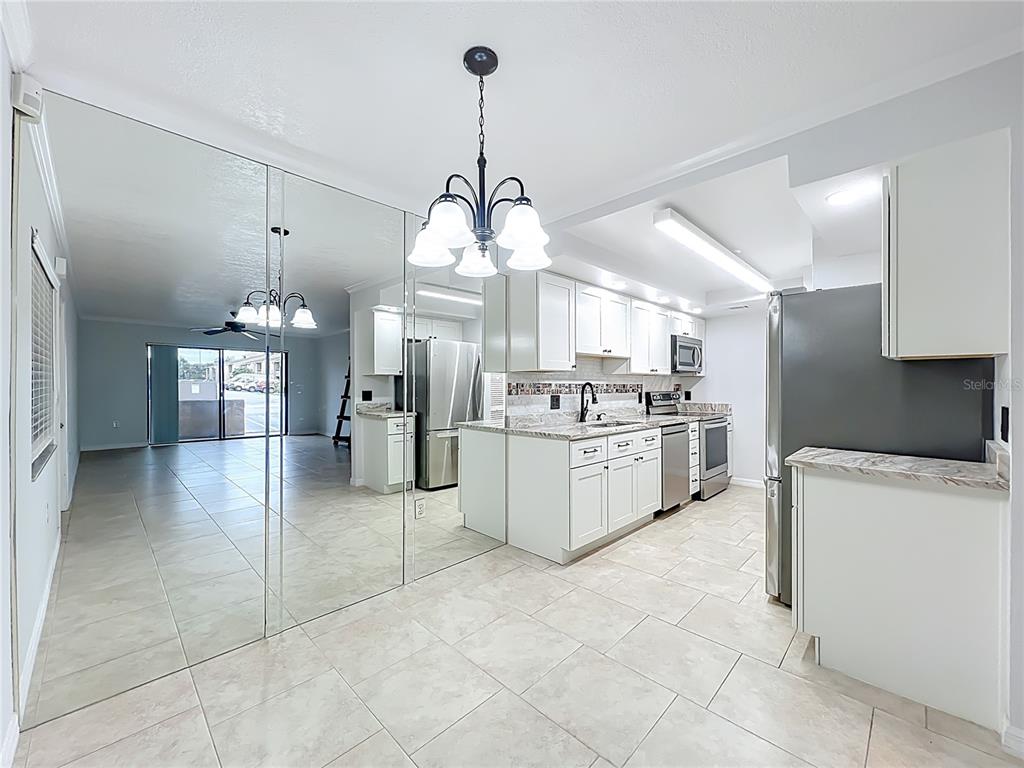 5249 Vineland Road Orlando, FL 32811 - Photo 12 of 42 a kitchen that has a lot of cabinets and refrigerator