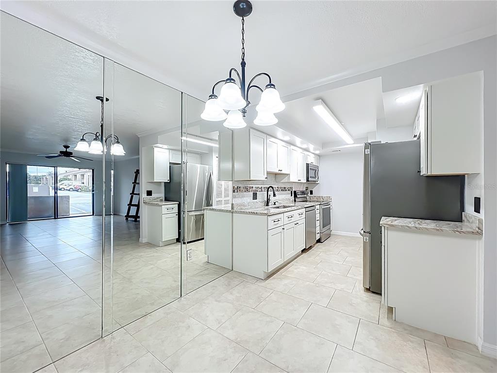 5249 Vineland Road Orlando, FL 32811 - Photo 13 of 42 a large kitchen with cabinets and stainless steel appliances