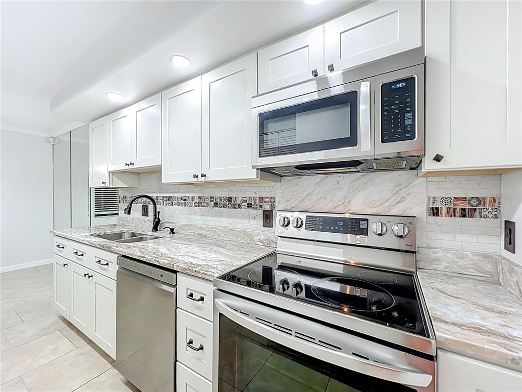 5249 Vineland Road Orlando, FL 32811 - Photo 16 of 42 a kitchen with appliances a sink and cabinets