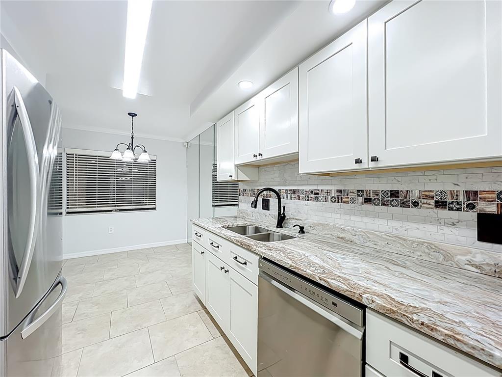 5249 Vineland Road Orlando, FL 32811 - Photo 17 of 42 a kitchen with stainless steel appliances granite countertop a sink a stove and a granite counter tops