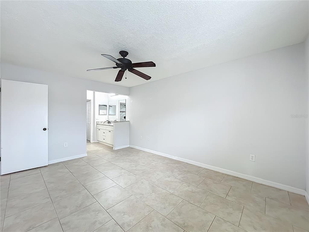 5249 Vineland Road Orlando, FL 32811 - Photo 19 of 42 a view of a livingroom with a ceiling fan and window