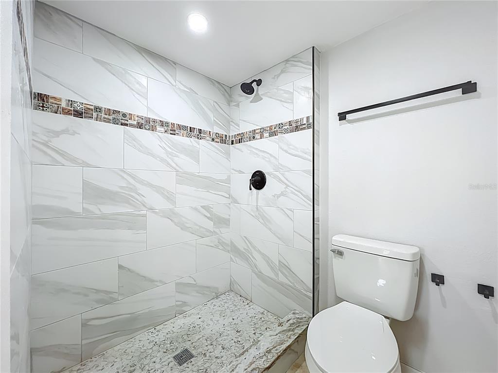 5249 Vineland Road Orlando, FL 32811 - Photo 25 of 42 a bathroom with a toilet and a shower