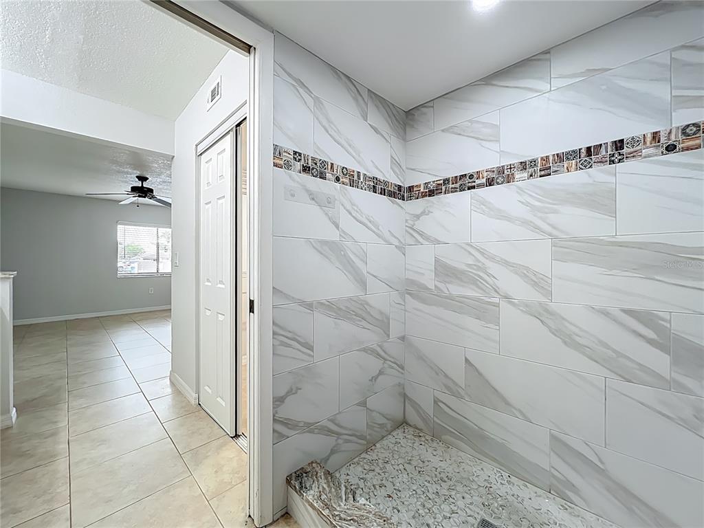 5249 Vineland Road Orlando, FL 32811 - Photo 26 of 42 a bathroom with a glass shower door