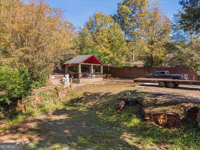 a view of swimming pool with lawn chairs under an umbrella