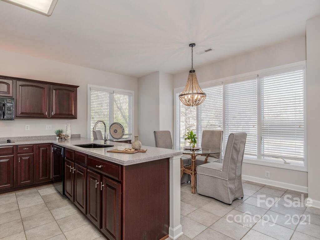 8683 Howard Drive Terrell, NC 28682 - Photo 19 of 46 a kitchen with stainless steel appliances granite countertop a stove a sink dishwasher a microwave oven with a dining table and chairs