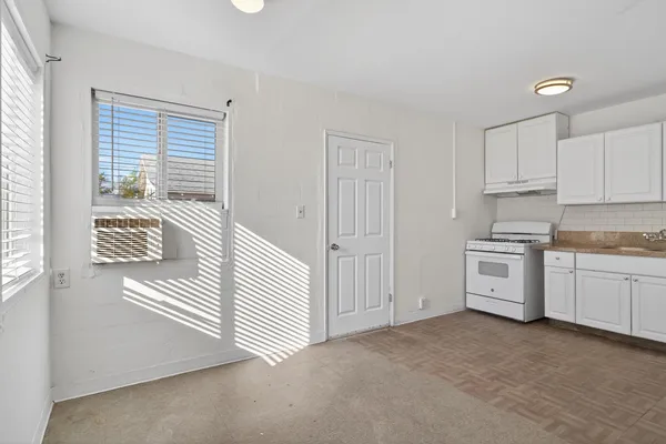 a kitchen with white cabinets and white appliances