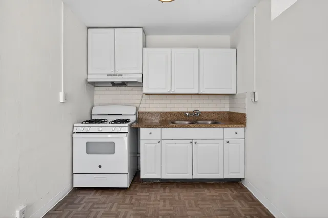 a kitchen with granite countertop white cabinets and stainless steel appliances