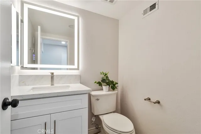 a bathroom with a sink toilet and a mirror