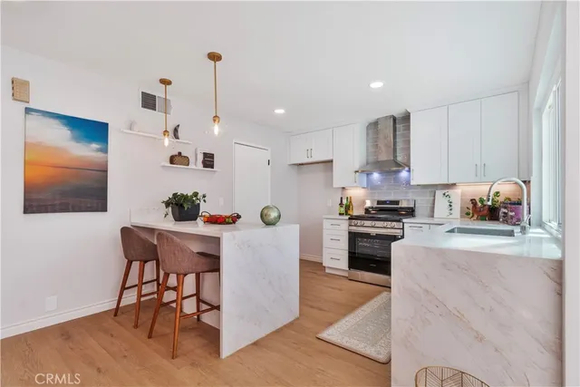 a kitchen with granite countertop stainless steel appliances and wooden floor