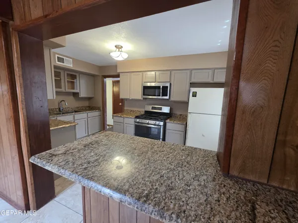 a kitchen with kitchen island a sink stove and refrigerator