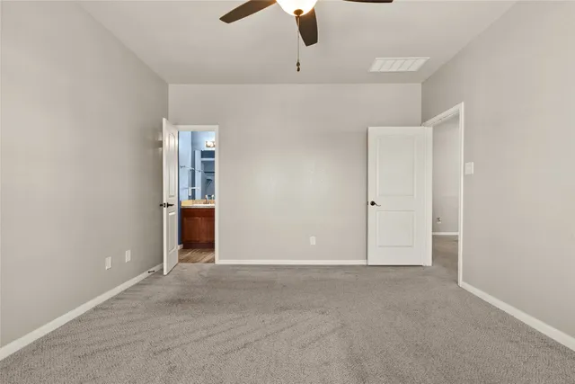 an empty room with ceiling fan and entryway