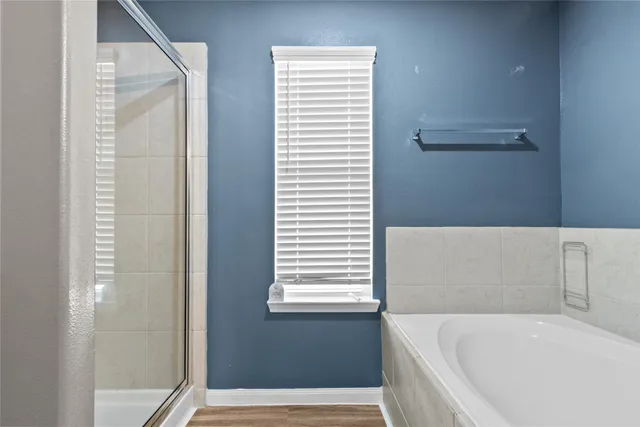 a bathroom with bathtub and window