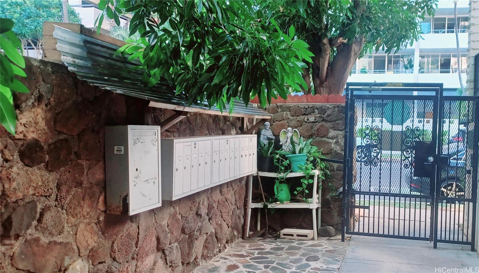 423 Kaiolu Street, Unit 106 Honolulu, HI 96815 - Photo 19 of 25 a view of a house with a small yard and wooden fence