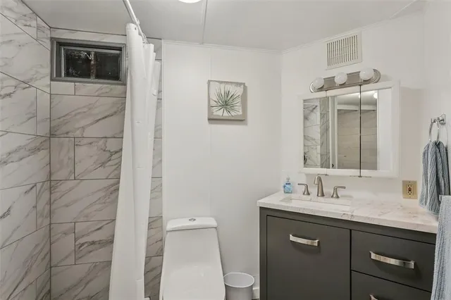 a bathroom with a sink mirror vanity and toilet