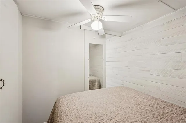 a bedroom with a bed and a chandelier fan