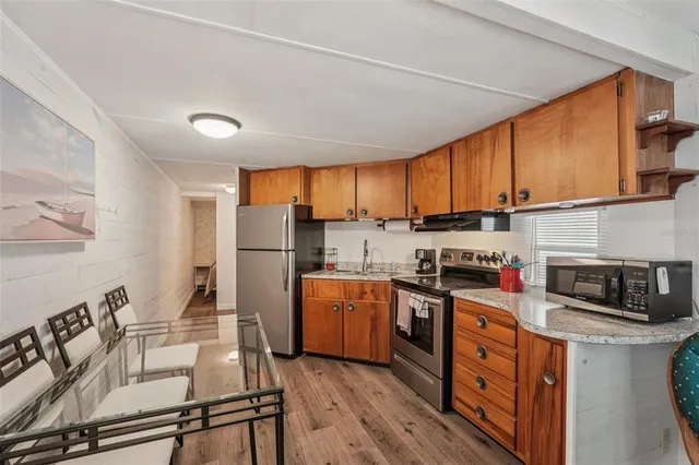 a kitchen with stainless steel appliances granite countertop a stove refrigerator sink and cabinets