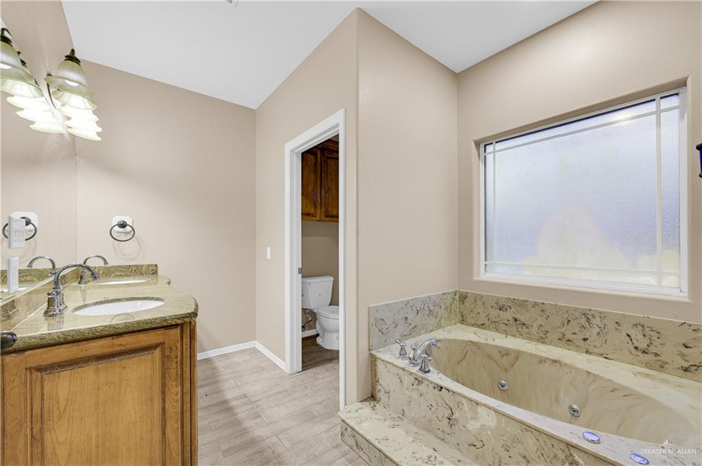 2005 Stuart Road Weslaco, TX 78599 - Photo 5 of 30 a bathroom with a tub sink and mirror