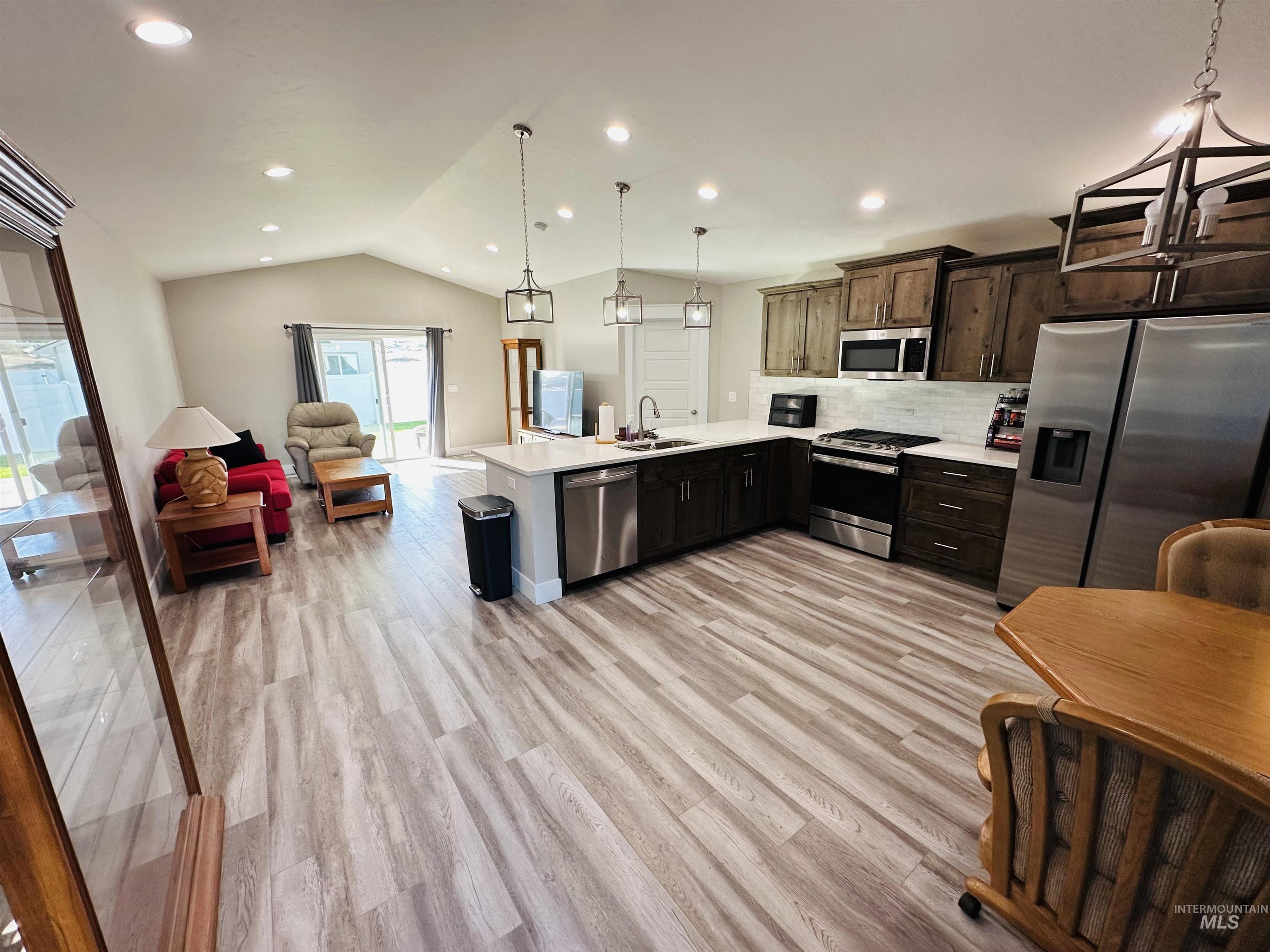 911 Campbell Street Vale, OR 97918 - Photo 37 of 37 Kitchen featuring stainless steel appliances, open floor plan, tasteful backsplash, a peninsula, and hanging light fixtures