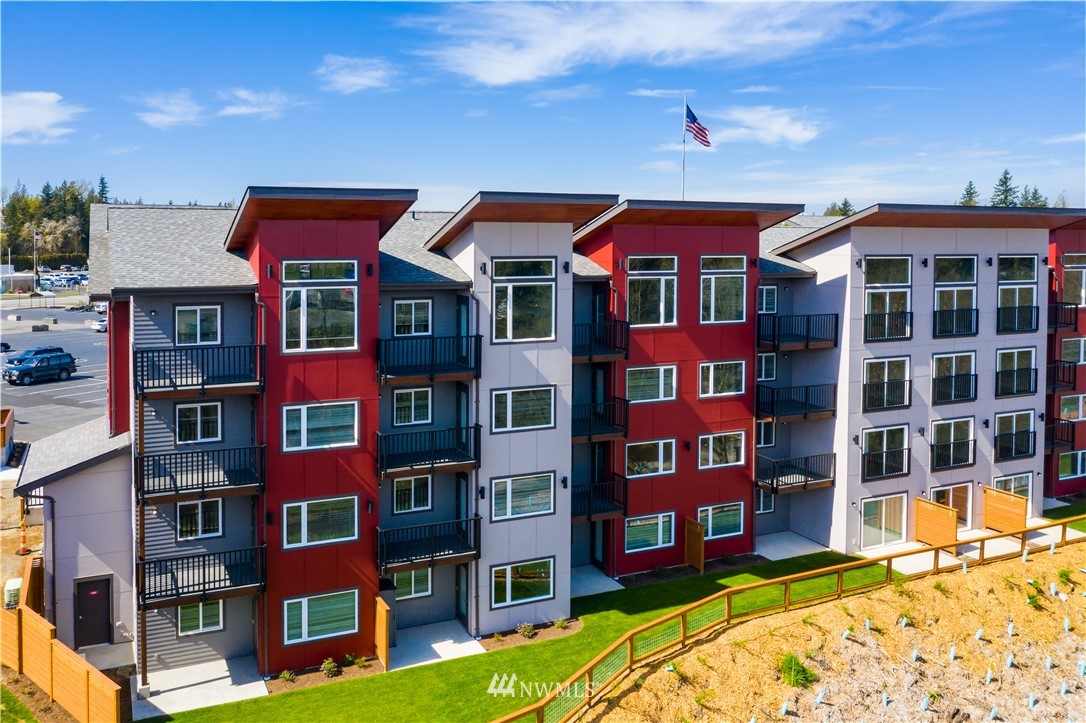 1882 Front Street, Unit 404 Lynden, WA 98264 - Photo 2 of 18 a front view of a residential apartment building with a yard