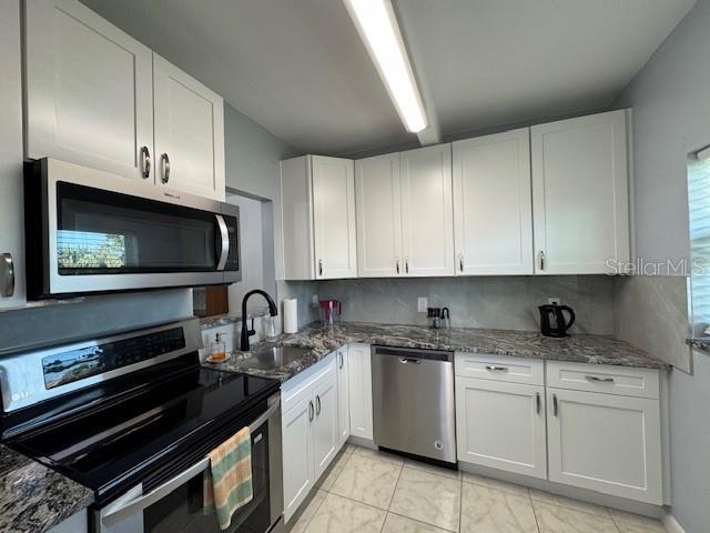 11485 Oakhurst Road, Unit 319 Largo, FL 33774 - Photo 20 of 63 a kitchen with appliances a sink and cabinets