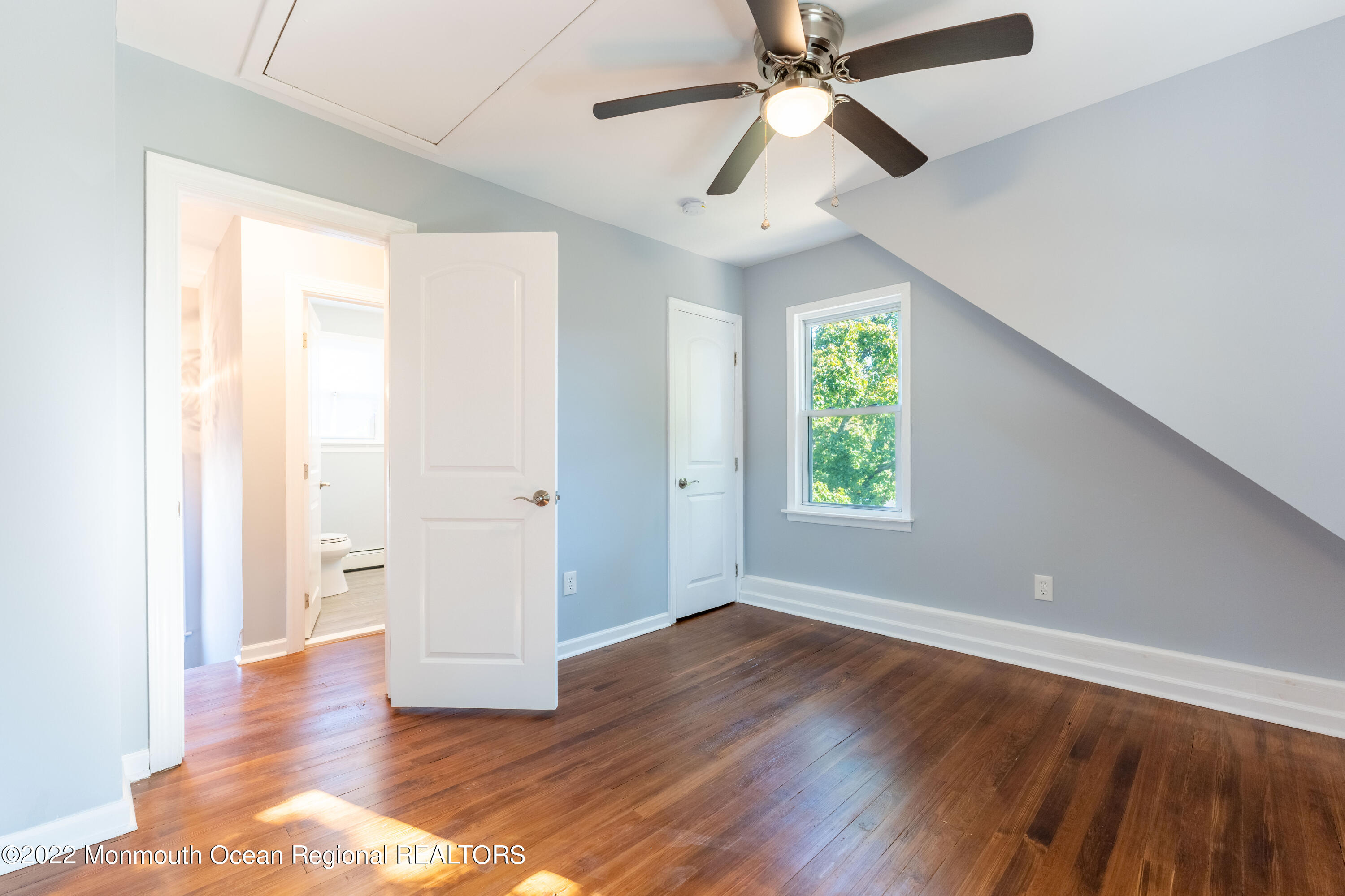 397 E Road Belford, NJ 07718 - Photo 23 of 34 an empty room with wooden floor chandelier fan and windows