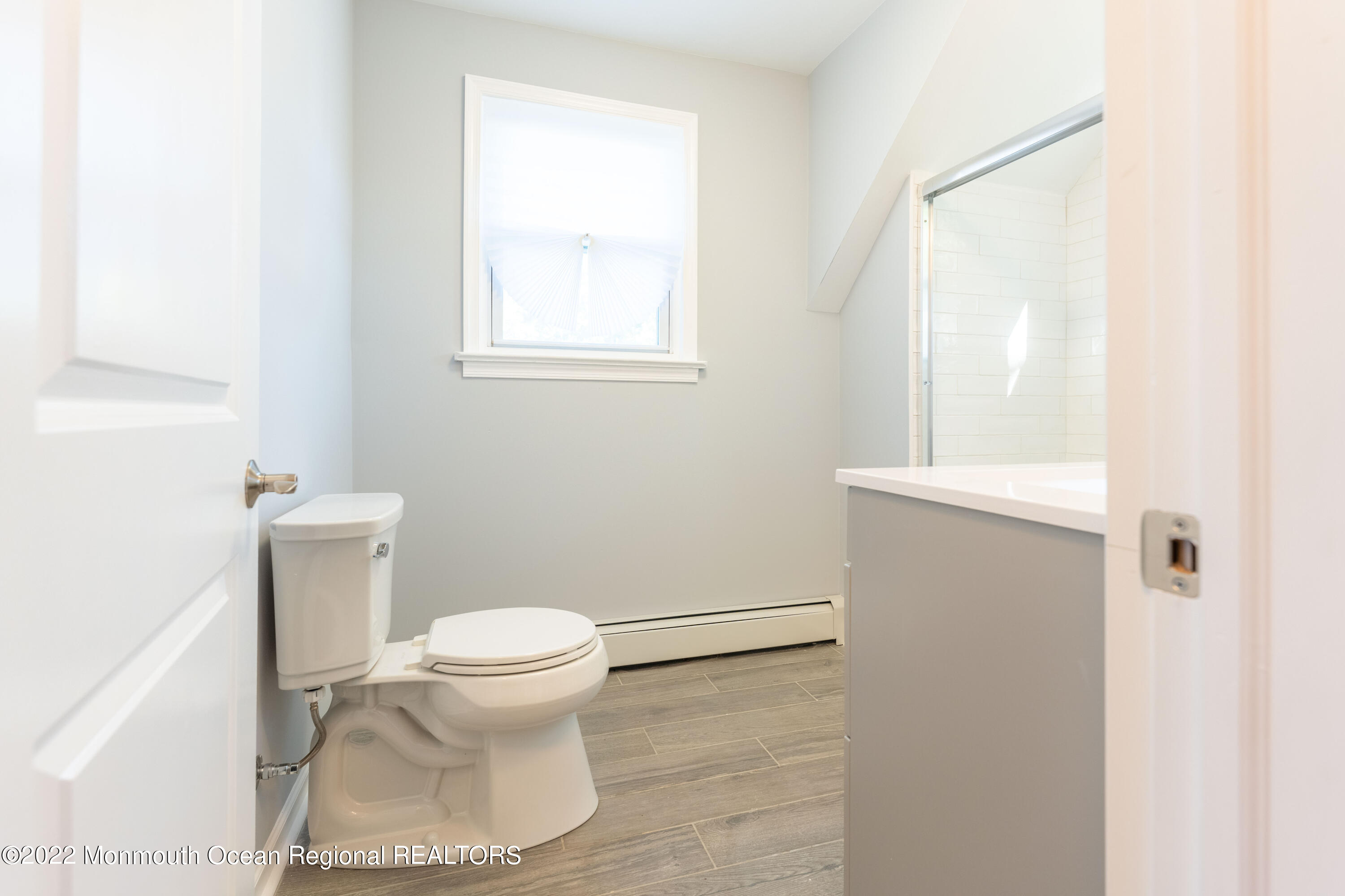 397 E Road Belford, NJ 07718 - Photo 26 of 34 a white toilet sitting next to a bathroom sink and vanity