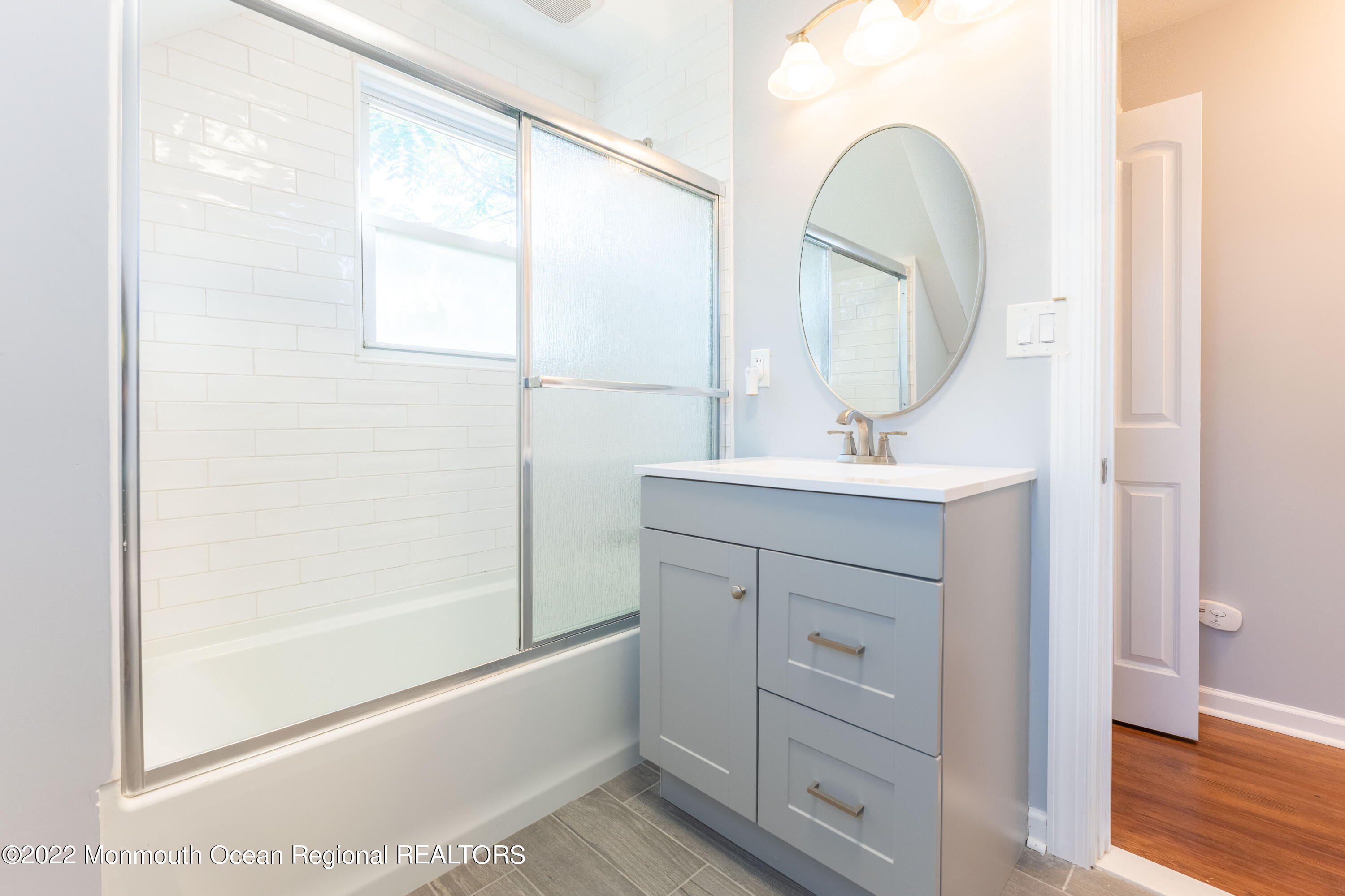 397 E Road Belford, NJ 07718 - Photo 27 of 34 a bathroom with a sink a mirror a vanity and a bathtub