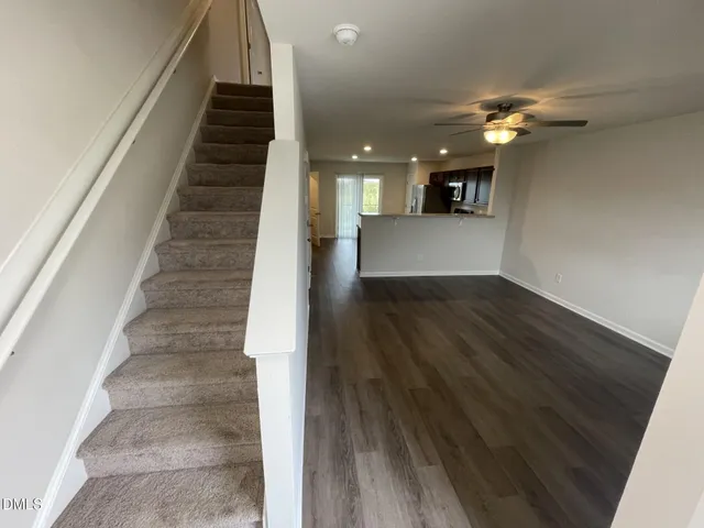 a view of a hallway with wooden floor and staircase