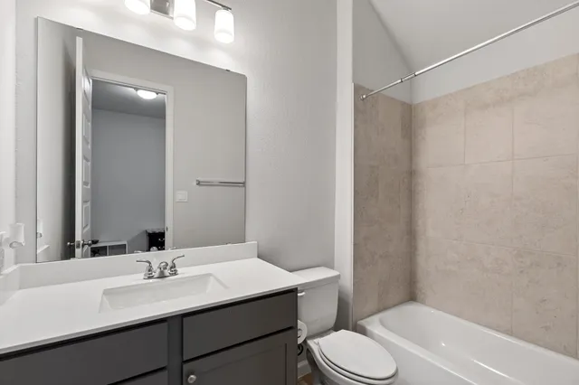 a bathroom with a sink toilet vanity and shower