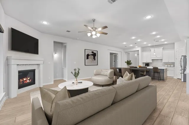 a living room with furniture a fireplace and a flat screen tv