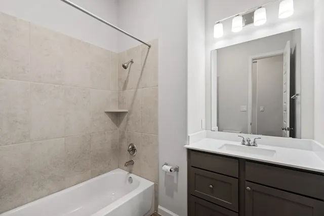 a bathroom with a tub sink shower and mirror