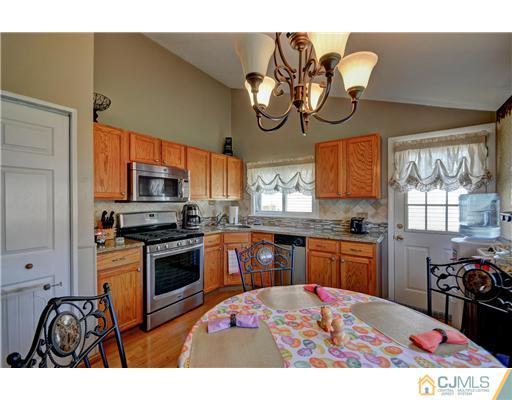 77 Westminster Road Colonia, NJ 07067 - Photo 3 of 8 a kitchen with stainless steel appliances granite countertop a stove a sink dishwasher and white cabinets with wooden floor