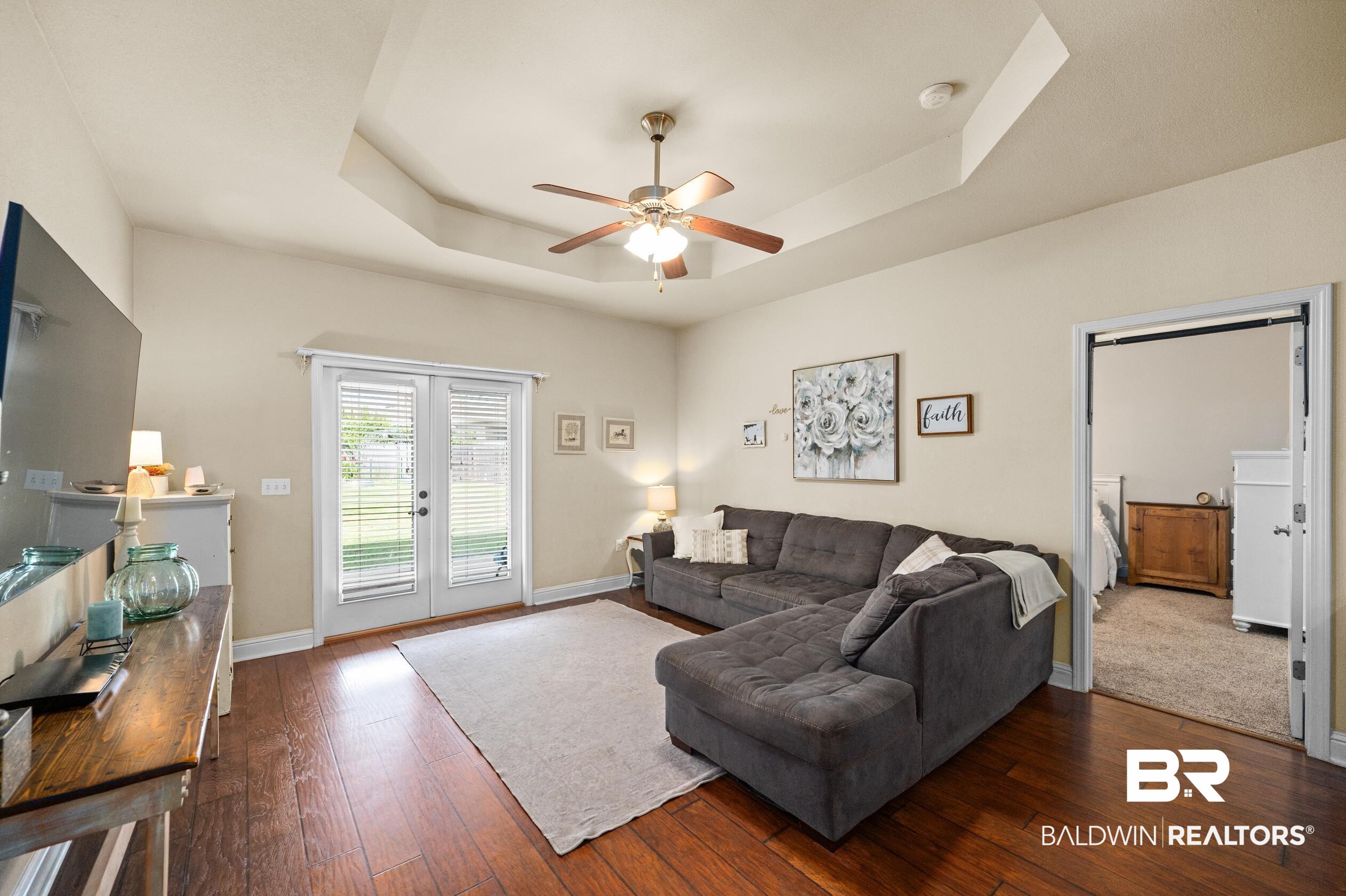 745 Bonaventure Street Fairhope, AL 36532 - Photo 12 of 36 Living room with a raised ceiling, ceiling fan, dark hardwood / wood-style floors, and french doors