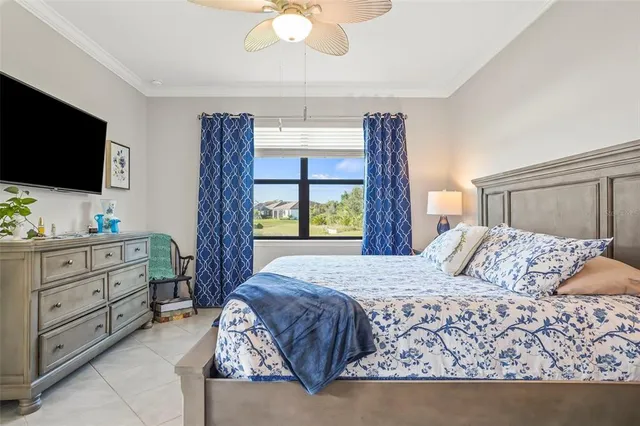 a bedroom with a large bed and a flat tv screen on dresser