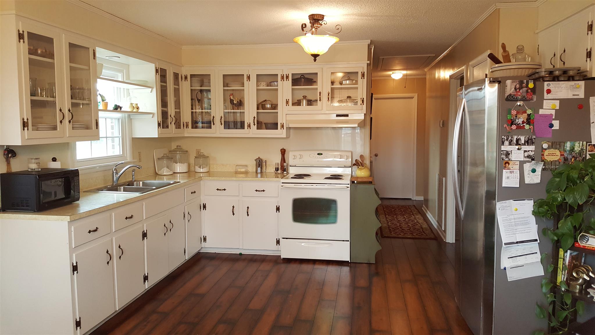 1445 Summitville Road Manchester, TN 37355 - Photo 13 of 22 a kitchen with granite countertop a refrigerator a sink dishwasher and white cabinets with wooden floor