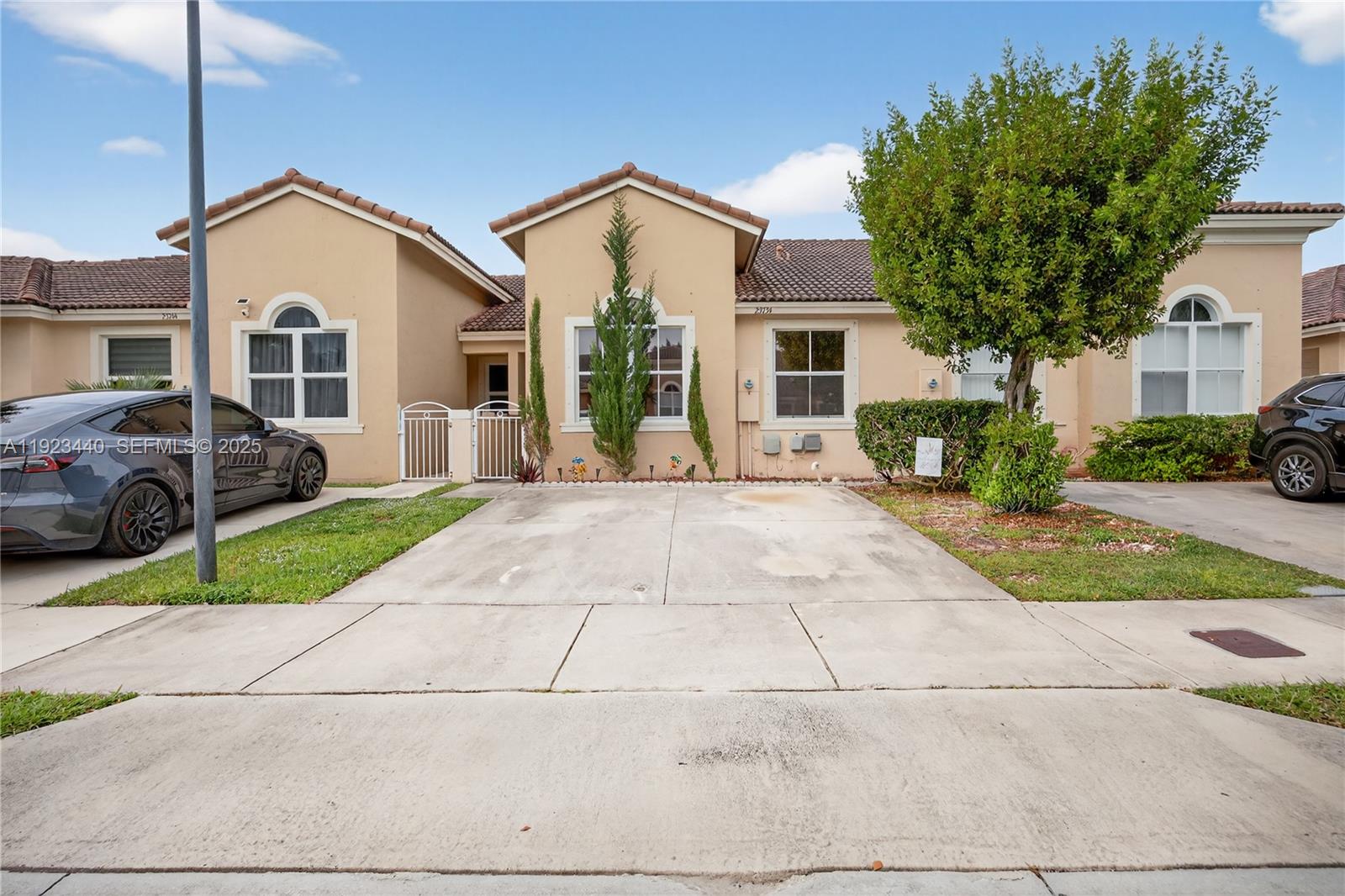 a front view of a house with a yard and potted plants