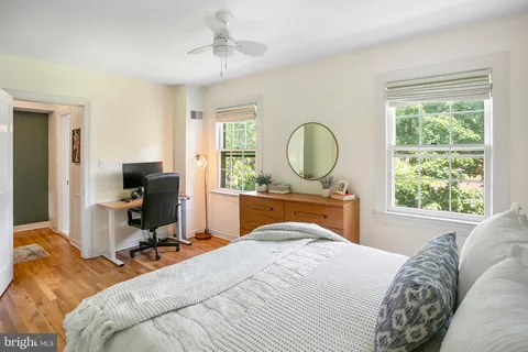 a bedroom with a bed a window and a chandelier