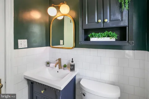 a bathroom with a toilet sink and mirror