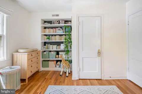 a view of a bedroom with baby crib and lounge chair