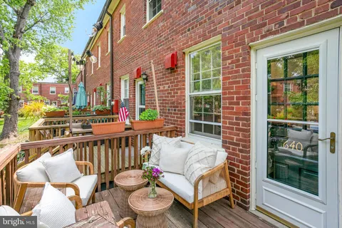 a view of a patio with couches chairs and wooden floor