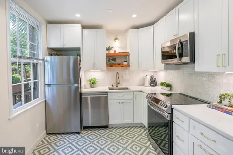 a kitchen with stainless steel appliances granite countertop a refrigerator sink and microwave