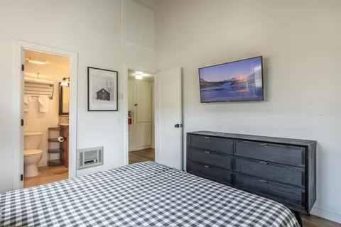 a bedroom with a bed and a painting on the wall
